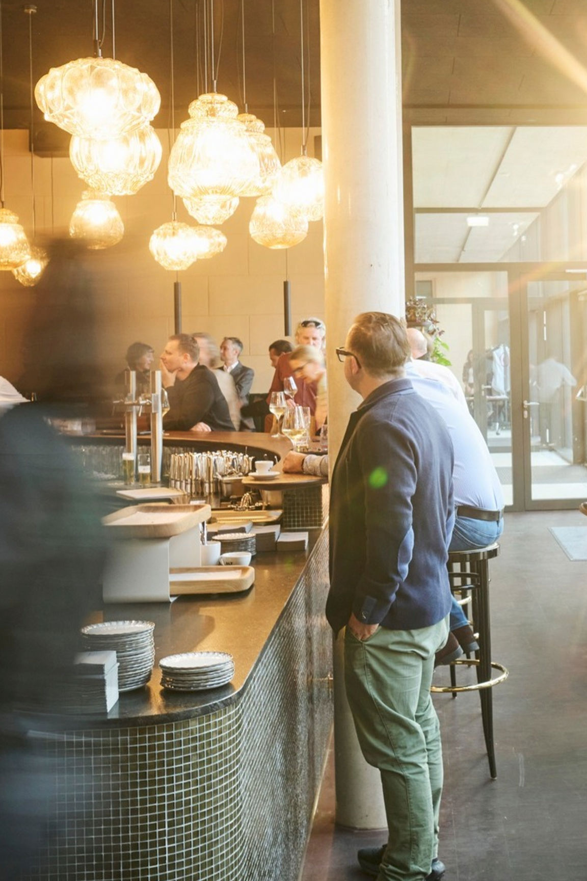 Gäste an der Bar des sophie7 unter Glaskugel-Leuchten